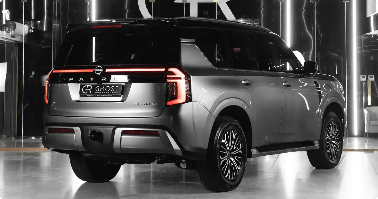 Premium Nissan Patrol driving past the Dubai skyline, luxury SUV rental